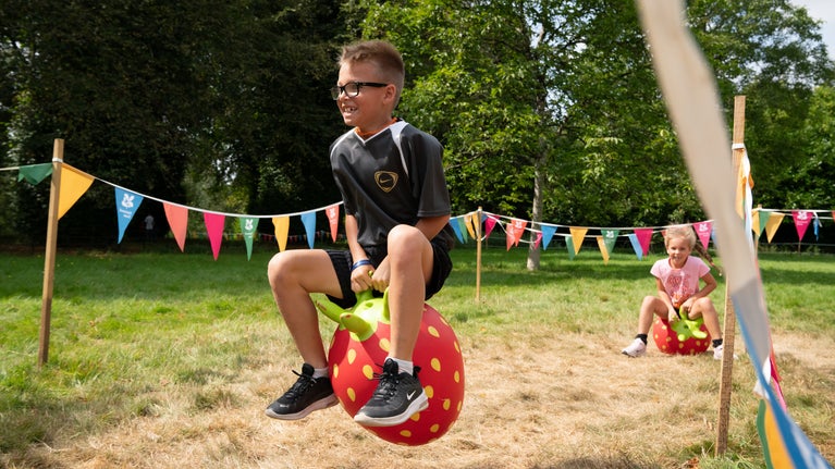 Children enjoying the bouncy fruits racetrack during the Summer of Play event at Kingston Lacy, Dorset